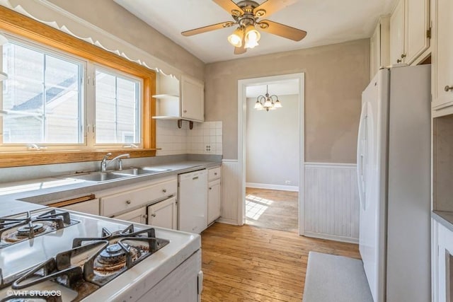 2140 Cedar Ct, Glenview, IL 60025 - kitchen featuring white appliances, a sink, light wood-style flooring, light countertops, and a chandelier