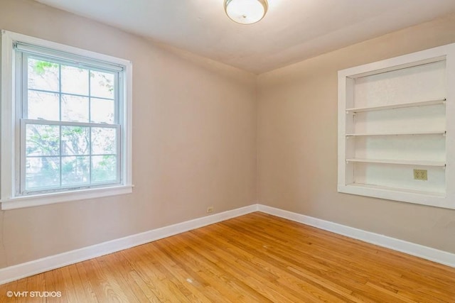 2140 Cedar Ct, Glenview, IL 60025 - unfurnished room with baseboards, light wood-style flooring, and built in shelves