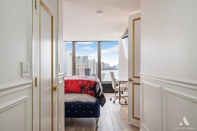 505 N Lake Shore Dr Unit 2017, Chicago, IL 60611 - bedroom with light wood-type flooring, wainscoting, a view of city, and a decorative wall