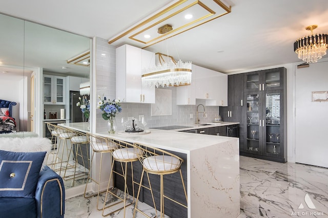 505 N Lake Shore Dr Unit 2017, Chicago, IL 60611 - kitchen featuring backsplash, white cabinetry, a peninsula, light marble finish floors, and a sink