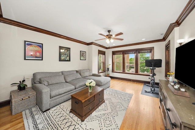 living room featuring light wood-style floors, ceiling fan, ornamental molding, and baseboards