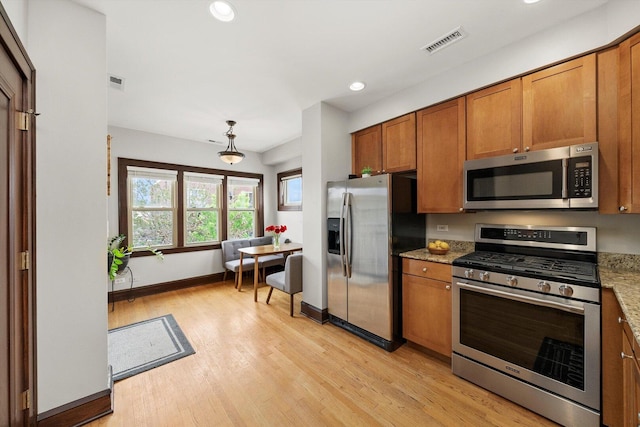 kitchen featuring stainless steel appliances, brown cabinetry, light wood-style floors, recessed lighting, and baseboards