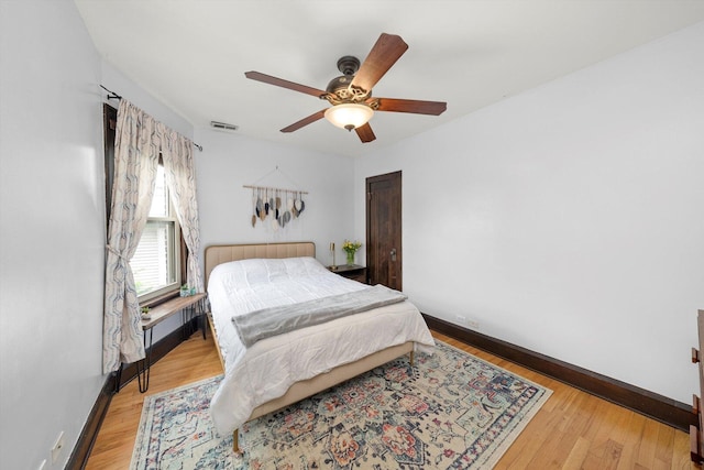 bedroom with baseboards, wood finished floors, and ceiling fan