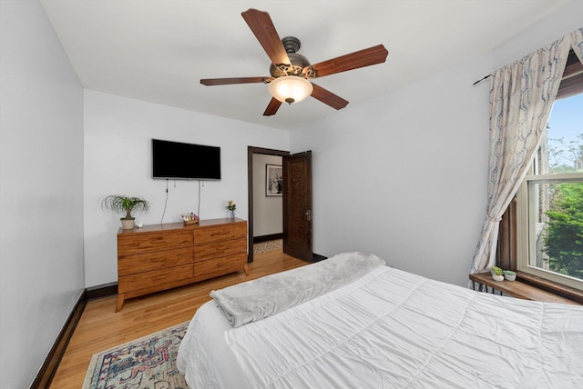 bedroom with wood finished floors, ceiling fan, and baseboards