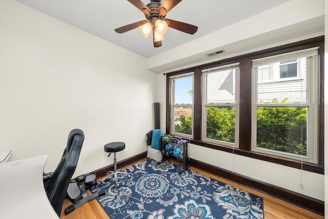 office area featuring wood finished floors, baseboards, and ceiling fan