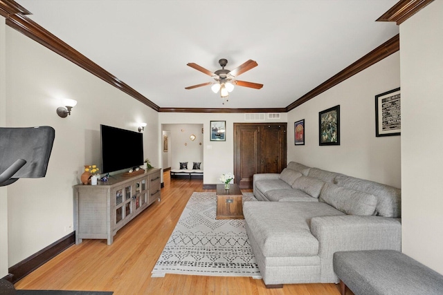 living area with ceiling fan, light wood-style flooring, ornamental molding, and baseboards