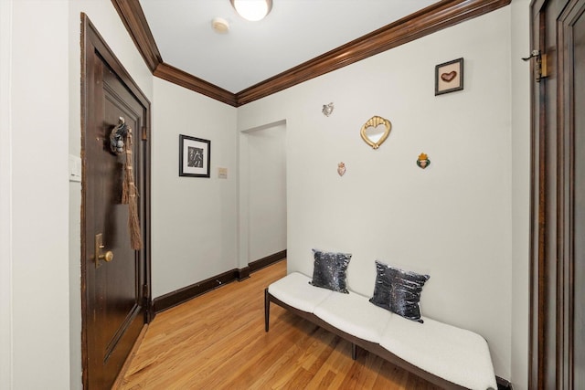 hall featuring ornamental molding, light wood-type flooring, and baseboards