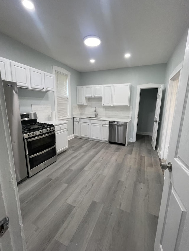1636 N Central Ave, Chicago, IL 60639 - kitchen featuring appliances with stainless steel finishes, white cabinetry, light countertops, light wood-type flooring, and recessed lighting