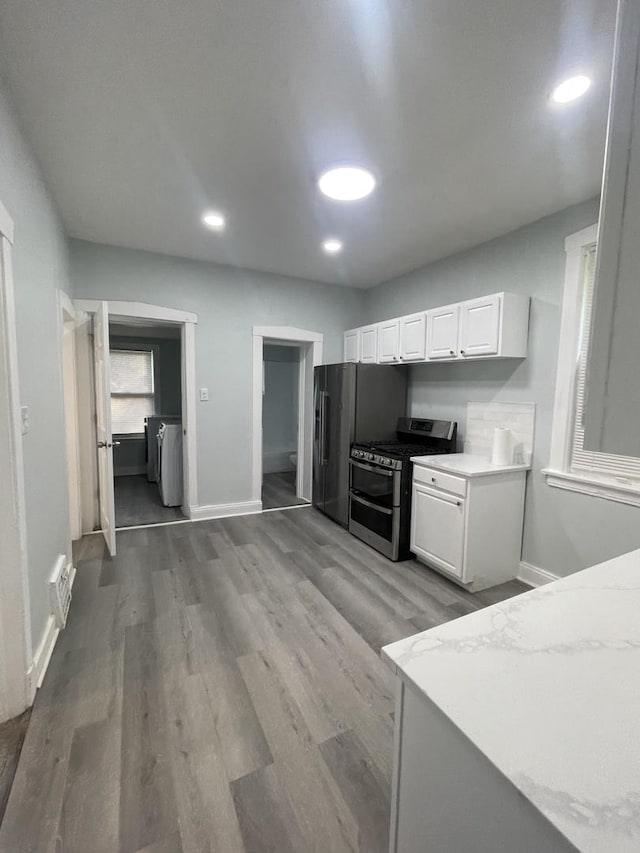 1636 N Central Ave, Chicago, IL 60639 - kitchen with range with two ovens, white cabinetry, light countertops, wood finished floors, and baseboards