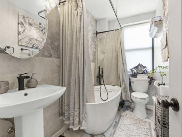 7321 S S Shore Dr Unit 11-B, Chicago, IL 60649 - bathroom with toilet, shower / bath combo, tile walls, and a sink