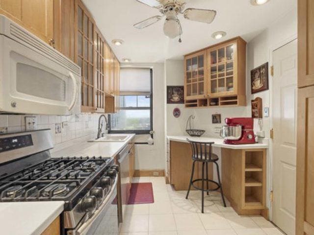 7321 S S Shore Dr Unit 11-B, Chicago, IL 60649 - kitchen featuring appliances with stainless steel finishes, a sink, a ceiling fan, brown cabinets, and recessed lighting
