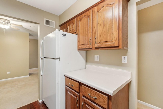 7333 Grand Ave Unit 102, Downers Grove, IL 60516 - kitchen featuring brown cabinets, a ceiling fan, freestanding refrigerator, baseboards, and light countertops