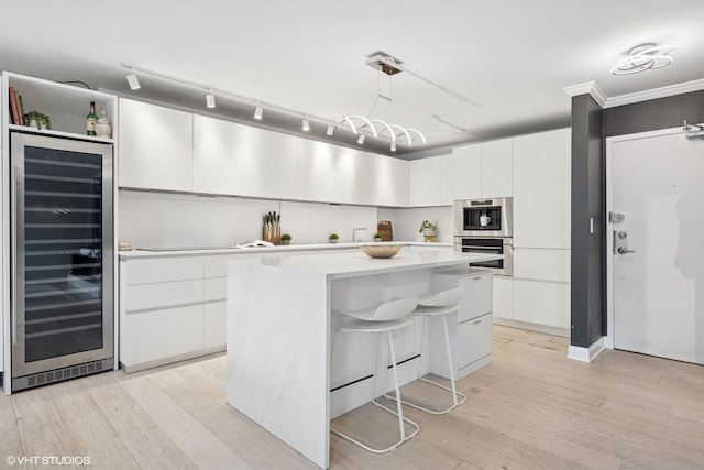 1516 N State Pkwy Unit 5D, Chicago, IL 60610 - kitchen with wine cooler, modern cabinets, light wood-type flooring, white cabinets, and ornamental molding
