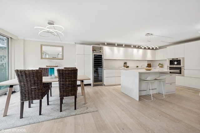 1516 N State Pkwy Unit 5D, Chicago, IL 60610 - dining area with wine cooler, light wood-type flooring, and a chandelier
