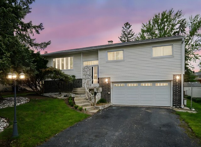 9040 Meadowview Dr, Hickory Hills, IL 60457 - bi-level home featuring asphalt driveway, a garage, a front lawn, and brick siding