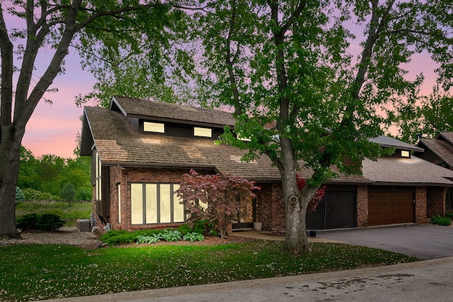 16 Lucas Dr, Palos Hills, IL 60465 - view of front facade with driveway, brick siding, an attached garage, a yard, and central AC