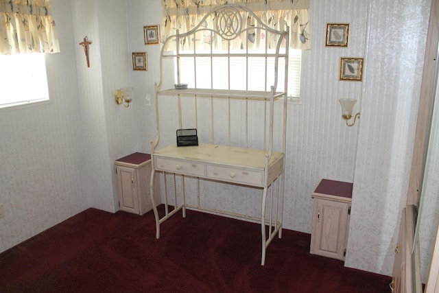home office featuring wallpapered walls and dark colored carpet