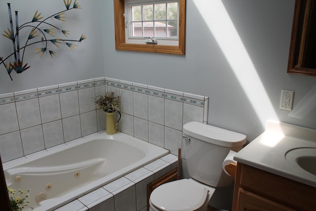 full bathroom with toilet, a jetted tub, and vanity