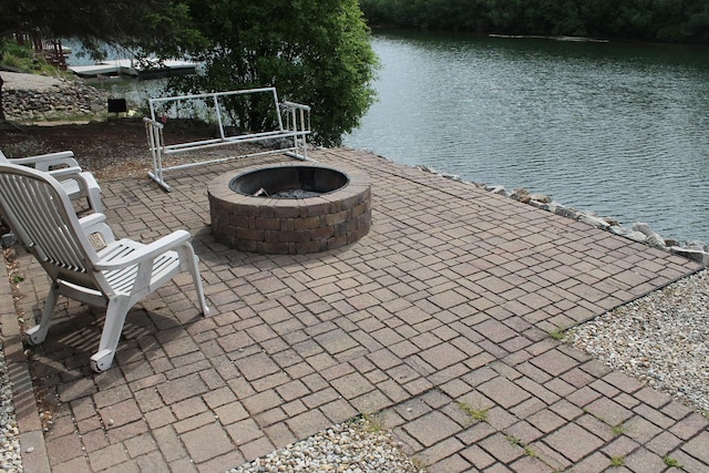 view of patio with a water view and a fire pit