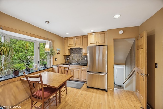 273 Desplaines Ave, Riverside, IL 60546 - kitchen with freestanding refrigerator, dark countertops, light wood-style flooring, decorative backsplash, and a sink