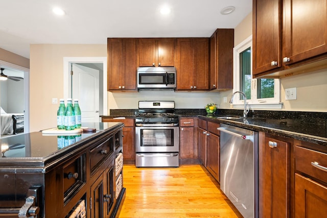 1000 S Ahrens Ave, Lombard, IL 60148 - kitchen featuring appliances with stainless steel finishes, light wood-style floors, dark stone countertops, and a ceiling fan