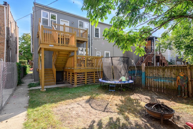3306 W Lemoyne St, Chicago, IL 60651 - back of property with a trampoline, an outdoor fire pit, stairs, a fenced backyard, and a wooden deck