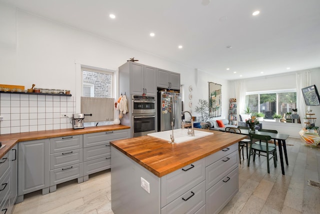 3306 W Lemoyne St, Chicago, IL 60651 - kitchen with butcher block countertops, gray cabinets, stainless steel appliances, a sink, and tasteful backsplash