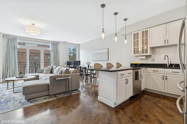 2523 N Halsted St Unit 2, Chicago, IL 60614 - kitchen featuring dark countertops, stainless steel dishwasher, glass insert cabinets, decorative backsplash, and a peninsula