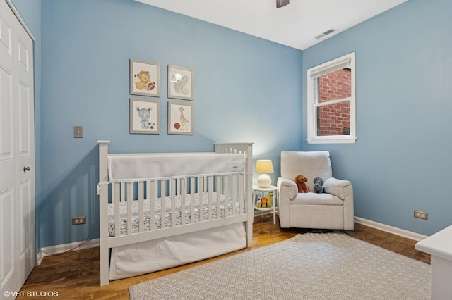 2523 N Halsted St Unit 2, Chicago, IL 60614 - bedroom featuring a crib, baseboards, wood finished floors, and a closet
