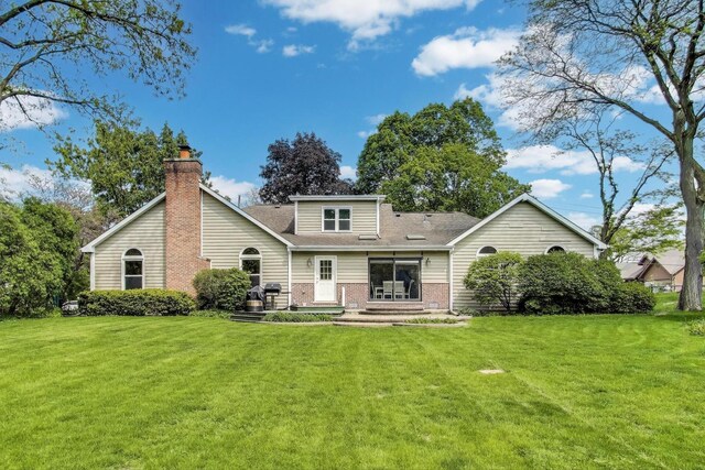 2481 Benton St, Palatine, IL 60067 - back of property with a yard, a chimney, brick siding, and a shingled roof
