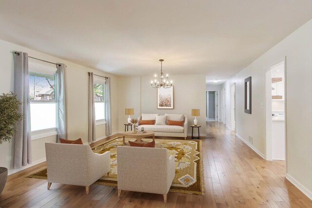 2481 Benton St, Palatine, IL 60067 - living room featuring light wood-style flooring, a chandelier, and baseboards