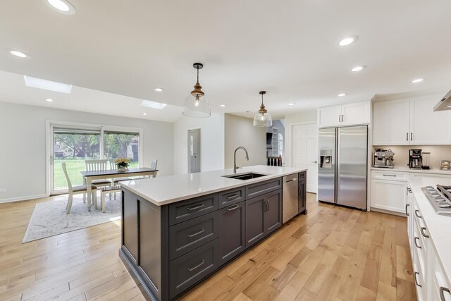 2481 Benton St, Palatine, IL 60067 - kitchen with stainless steel appliances, a sink, white cabinetry, a skylight, and light countertops