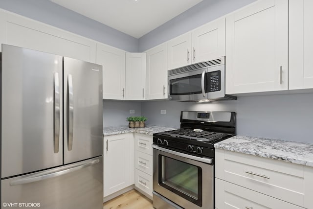 39674 N Warren Ln Unit 0, Beach Park, IL 60083 - kitchen featuring stainless steel appliances, white cabinetry, light stone countertops, and light wood-style floors