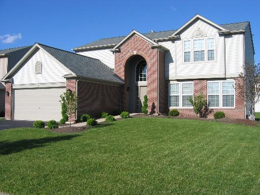 254 S Cranberry St, Bolingbrook, IL 60490 - view of front facade with brick siding, an attached garage, a front lawn, and driveway