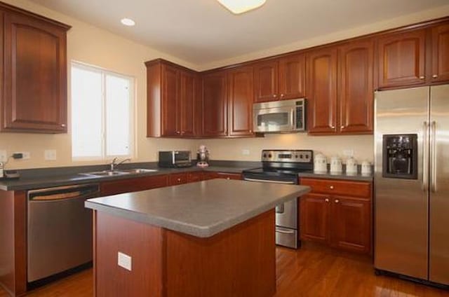254 S Cranberry St, Bolingbrook, IL 60490 - kitchen with stainless steel appliances, a sink, dark countertops, dark wood-style floors, and a kitchen island