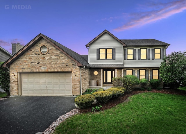 1715 Chestnut Hill Rd, Plainfield, IL 60586 - traditional home with asphalt driveway, a garage, brick siding, a front yard, and covered porch