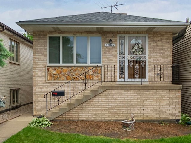 6856 W Montrose Ave, Harwood Heights, IL 60706 - view of exterior entry featuring roof with shingles and brick siding