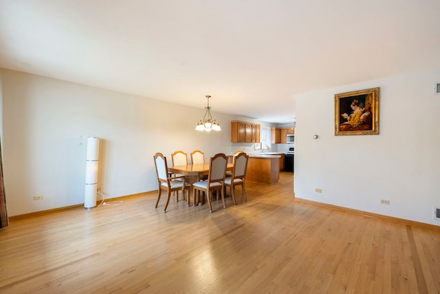 6856 W Montrose Ave, Harwood Heights, IL 60706 - dining space with light wood-style flooring and a chandelier
