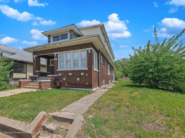 12155 S Normal Ave, Chicago, IL 60628 - view of front of property with brick siding, a front lawn, and a porch