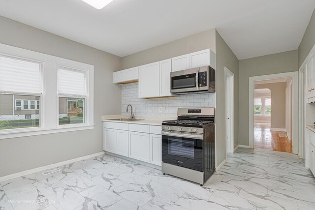 12155 S Normal Ave, Chicago, IL 60628 - kitchen with stainless steel appliances, a sink, light marble finish flooring, and baseboards