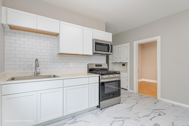 12155 S Normal Ave, Chicago, IL 60628 - kitchen featuring appliances with stainless steel finishes, a sink, light marble finish flooring, light countertops, and decorative backsplash