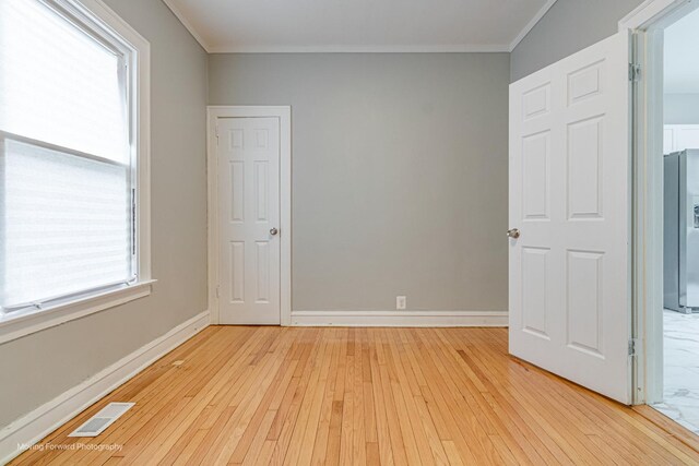 12155 S Normal Ave, Chicago, IL 60628 - unfurnished room featuring light wood finished floors, crown molding, and baseboards