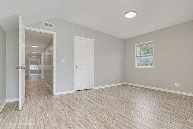 12155 S Normal Ave, Chicago, IL 60628 - unfurnished room with light wood-type flooring, lofted ceiling, and baseboards