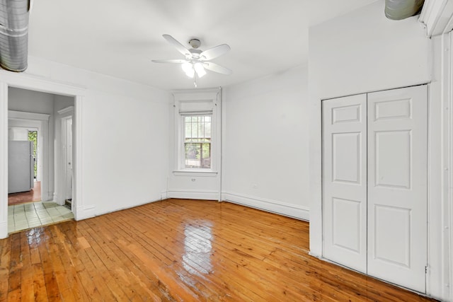 9035 S Burley Ave, Chicago, IL 60617 - unfurnished bedroom featuring multiple windows, light wood finished floors, freestanding refrigerator, and ceiling fan