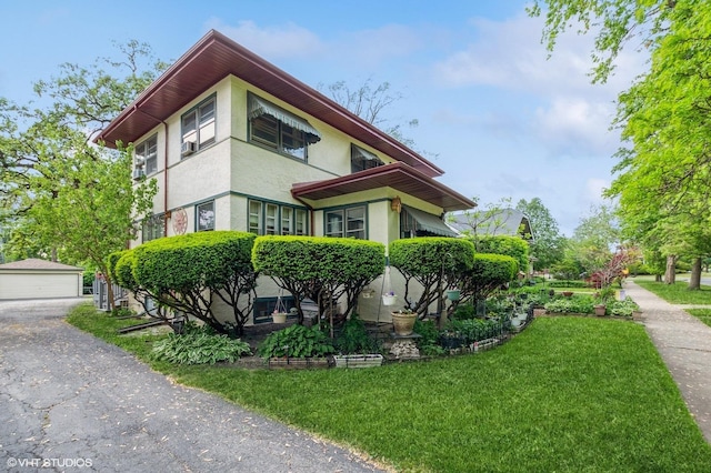 10716 S Hoyne Ave, Chicago, IL 60643 - view of side of property with a lawn, an outdoor structure, stucco siding, and a detached garage