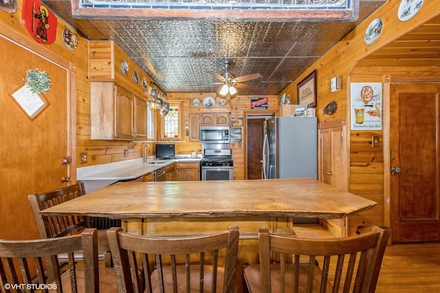 10716 S Hoyne Ave, Chicago, IL 60643 - kitchen featuring stainless steel appliances, wooden walls, light countertops, an ornate ceiling, and a ceiling fan