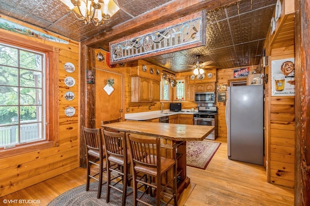 10716 S Hoyne Ave, Chicago, IL 60643 - kitchen featuring stainless steel appliances, an ornate ceiling, wooden walls, light wood-type flooring, and a chandelier