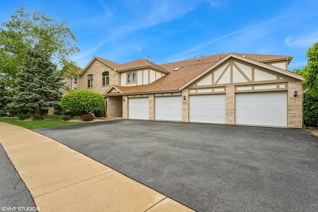 18513 Pine Lake Dr Unit 1, Tinley Park, IL 60477 - view of front facade featuring an attached garage, brick siding, and asphalt driveway