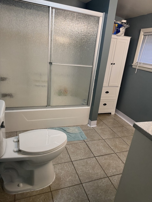 bathroom featuring tile patterned floors, shower / bath combination with glass door, and baseboards