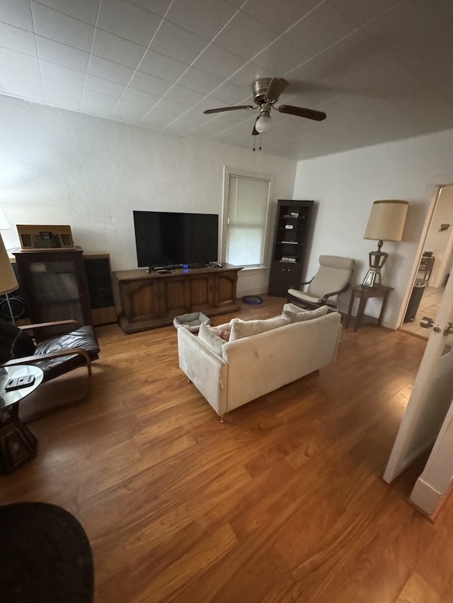 living room featuring light wood-type flooring and a ceiling fan